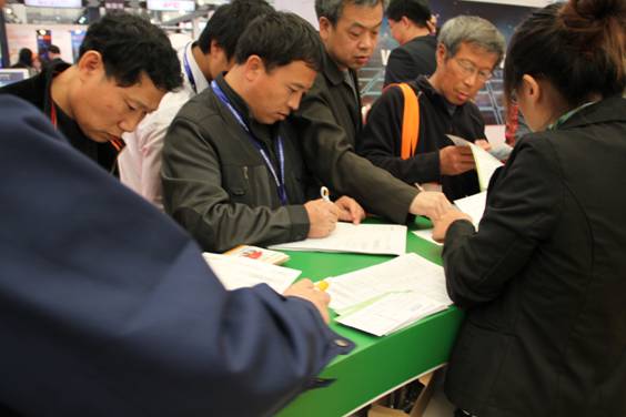 我工作人員指導(dǎo)觀(guān)眾認(rèn)真填寫(xiě)Expo Pack查詢(xún)表場(chǎng)景一